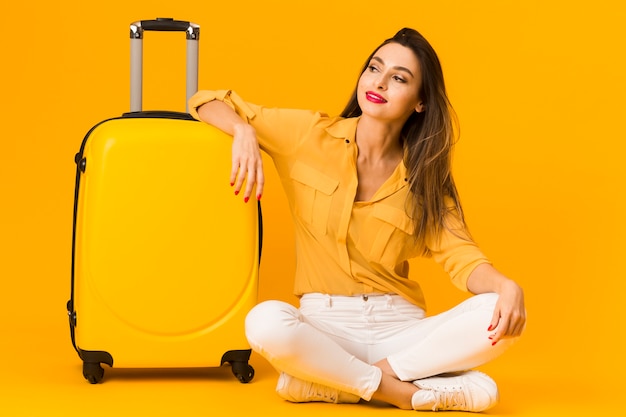 Foto vooraanzicht van vrouw gelukkig poseren naast haar bagage