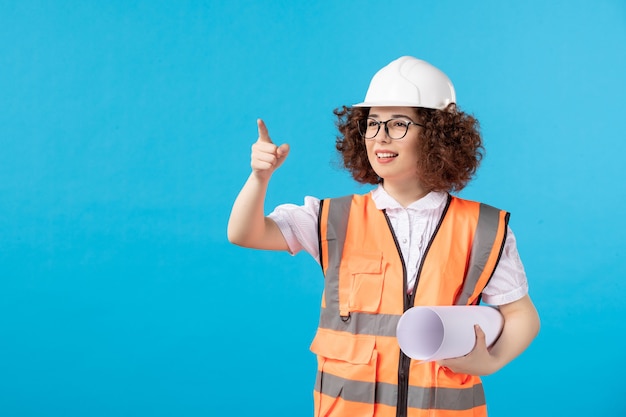 Vooraanzicht van werkneemster in uniform op de blauwe muur