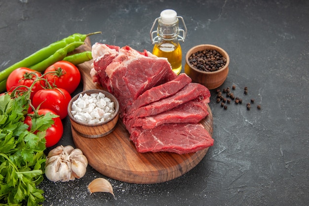 Vooraanzicht vers gesneden vlees met tomaten en groenten op donkere achtergrond vlees eten maaltijd dier barbecue kleur slager diner