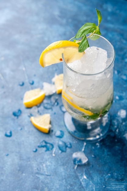 Vooraanzicht verse koele limonade met ijs en citroen op lichtblauwe achtergrond fruit water cocktail drinken kleurenbalk koud