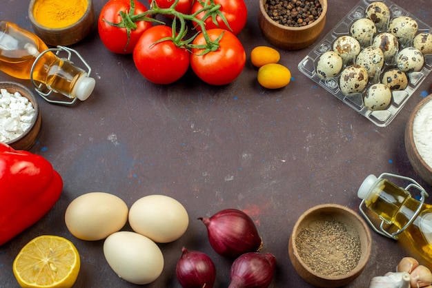 Vooraanzicht verse rode tomaten met eieren, kruiden en bloem op donkere achtergrond, groentesalade, peper, snack, gezondheidsdieet, melk