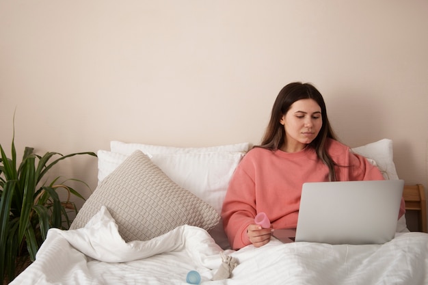 Foto vooraanzicht vrouw in bed met laptop