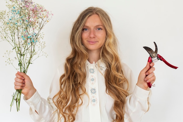 Foto vooraanzicht vrouw met bloemen en schaar