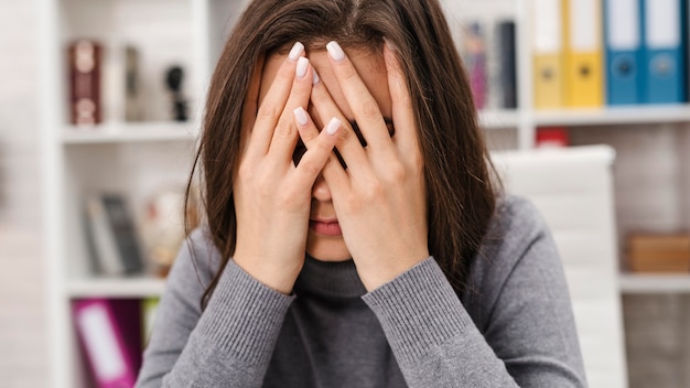 Foto vooraanzicht vrouw met hoofdpijn tijdens het werken vanuit huis