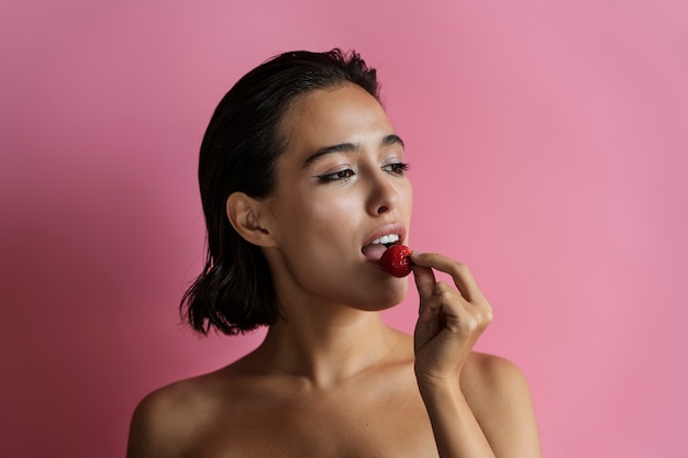 Vooraanzicht vrouw poseren met aardbei