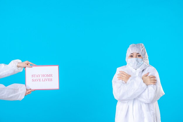 vooraanzicht vrouwelijke arts in beschermend pak en masker rillend op blauwe achtergrond isolatie covid wetenschap gezondheid virus medische ziekte pandemie