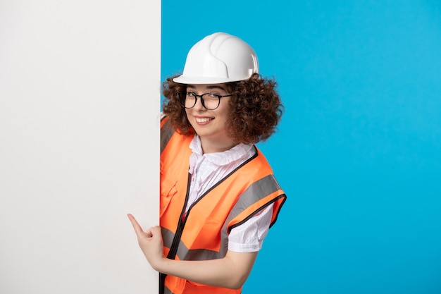 Vooraanzicht vrouwelijke bouwer in uniform op het blauw