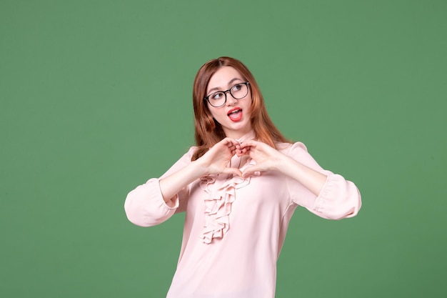 Vooraanzicht vrouwelijke leraar in roze blouse op groen