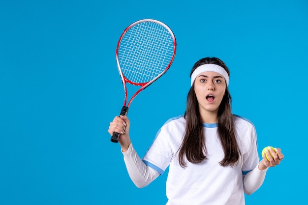 Vooraanzicht vrouwelijke tennisspeelster met tennisracket en bal