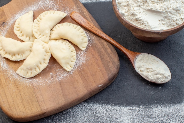 vooraanzicht witte bloem met rauwe kleine hotcakes op donkere achtergrond deeg oven cake taart koekje bakken koken