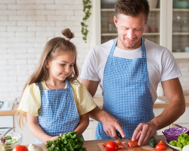 Foto vooraanzichtvader en meisje die samen koken