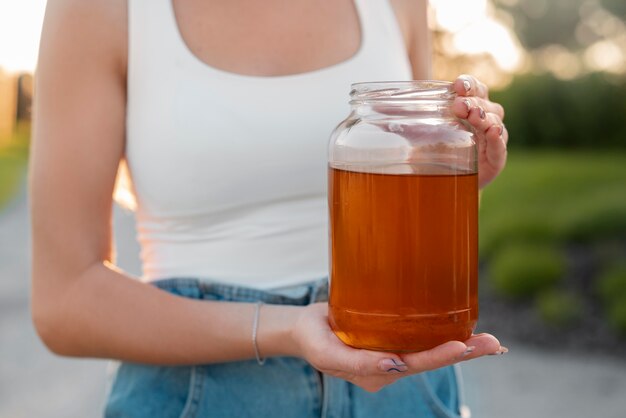 Foto vooraanzichtvrouw met heerlijke kombucha in openlucht