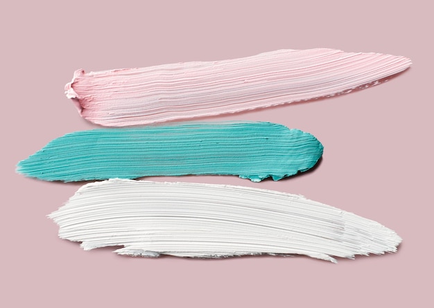 Voorbeelden van kleurcorrigerende concealers Op roze achtergrond Swatch-uitstrijkjes van crème make-upbasis
