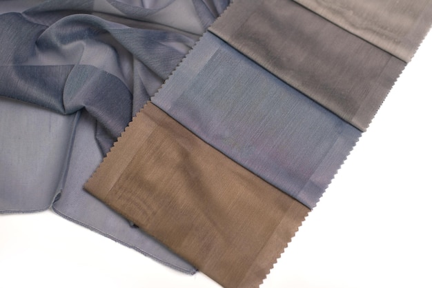 Voorbeelden van licht doorzichtige gordijnstof in bruine en blauwe kleuren op een witte achtergrond