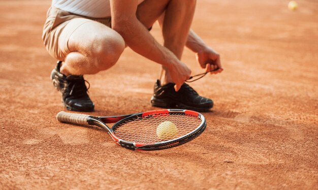 Voorbereiden. jonge tennisser in sportieve kleding is buiten op het veld.