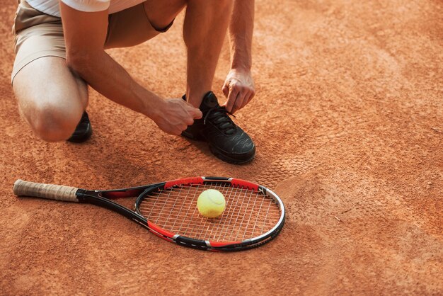 Voorbereiden. jonge tennisser in sportieve kleding is buiten op het veld.