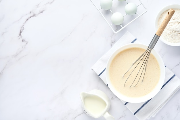 voorbereiding van deeg voor thuis pannenkoeken voor het ontbijt. ingrediënten op tafel