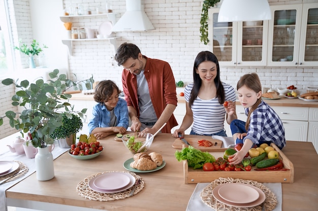 Voorbereiding van een salade jonge mooie familie samen koken in de moderne keuken thuis moeder en