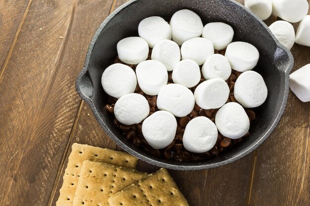 Voorbereiding van smores dip bereid met grote marshmallows in gietijzeren pan.