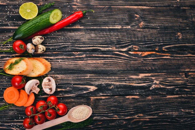 Voorbereiding voor het koken Cherry Tomaten stokbrood kwarteleitjes komkommer champignons Op een houten achtergrond Bovenaanzicht Kopieer ruimte