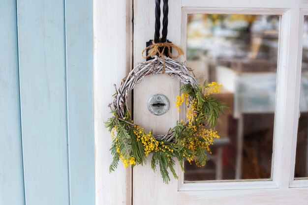 Voordeur met krans van gele mimosa bloemen