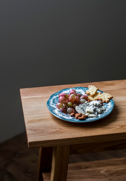 Voorgerecht bord met druiven gorgonzola notencracker op een houten tafel