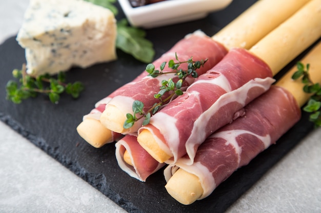 Voorgerecht met prosciutto, ham, blauwe kaas en in de zon gedroogde tomaten voor vakantie