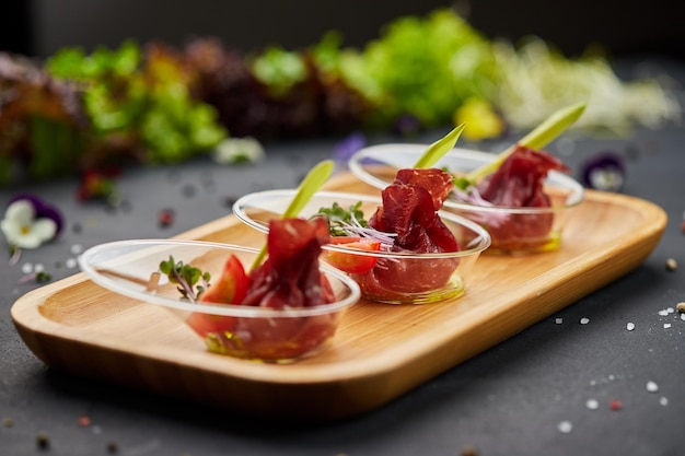 Foto voorgerecht van gedroogde ham prosciutto plakjes op een donkere achtergrond foto voor restaurantmenu