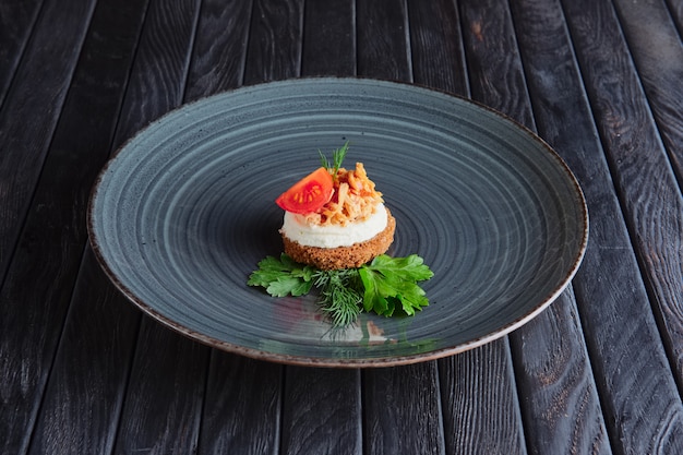 Voorgerecht voor ontvangst. Vlees, ricotta en een stuk tomatenkers op bruin brood