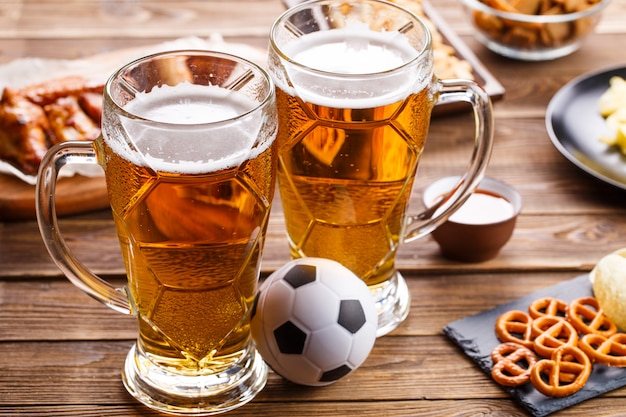 Voorgerechten en bier op tafel om de voetbalwedstrijd te bekijken.