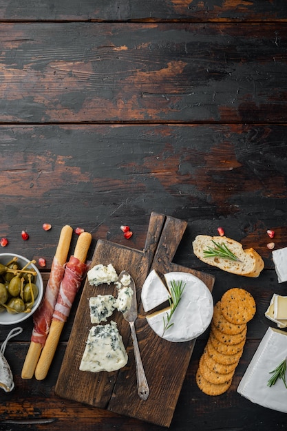 Foto voorgerechten tafel met differents antipasti set, op donkere houten achtergrond, bovenaanzicht met kopie ruimte voor tekst