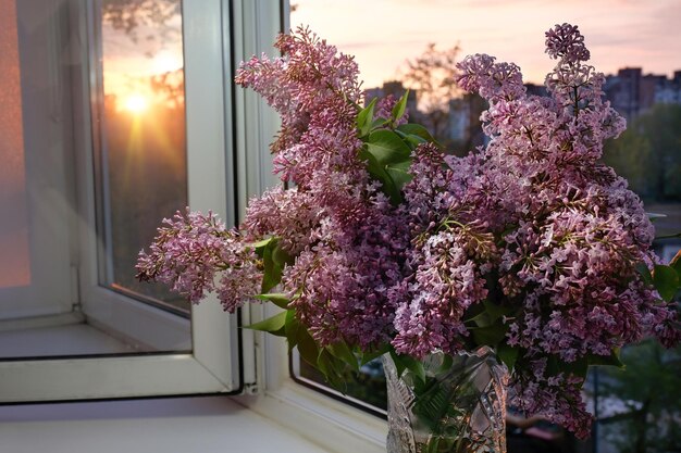 Voorjaarsboeket van seringen op de vensterbank bij zonsondergang Mooie bloemen