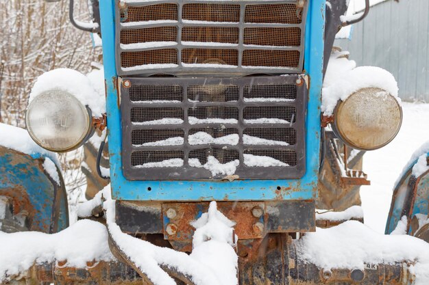 Voorkant van oude tractor bedekt met sneeuw