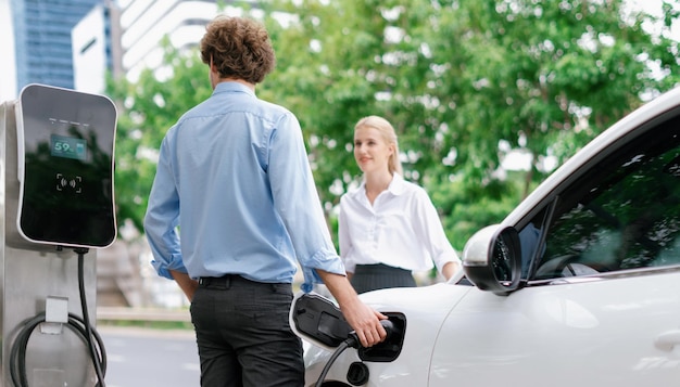 Foto vooruitstrevende zakenman en zakenvrouw bij oplaadpunt en ev-auto