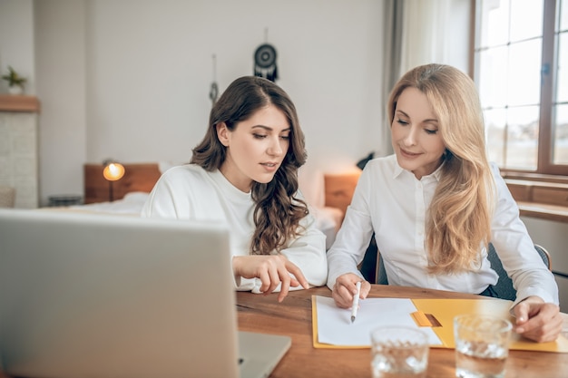 Voorwaarden van de deal. Twee vrouwen die aan tafel zitten en een deal bespreken