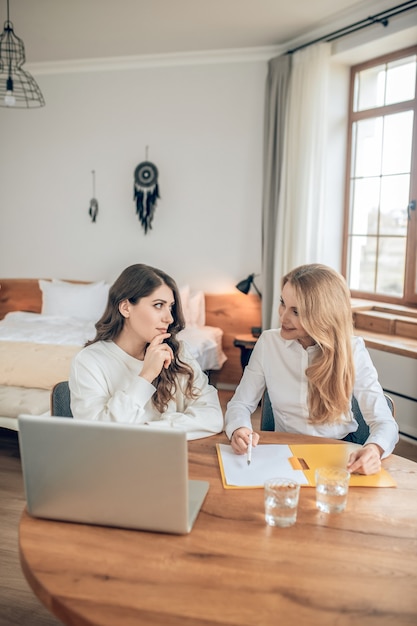 Voorwaarden van de deal. Twee vrouwen die aan tafel zitten en een deal bespreken