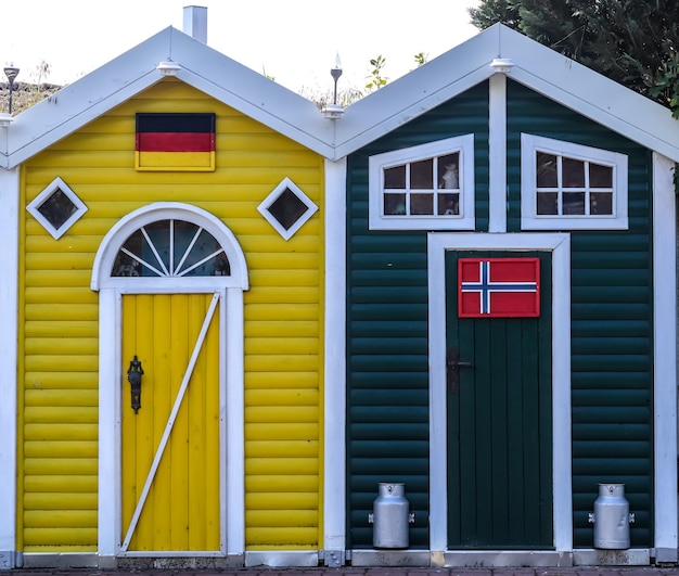 Foto voorzijde van kleurrijke kleine houten huizen met scandinavische vlaggen