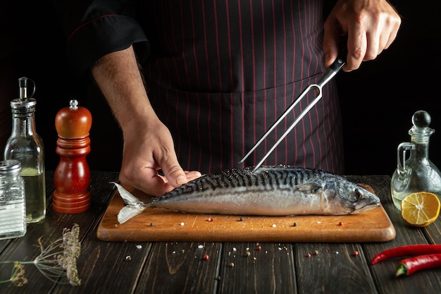 Vork in de hand van de chef tijdens het bereiden van een heerlijke lunch met Scomber