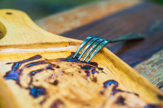 Vork op de lege houten plaat van de chocoladecake