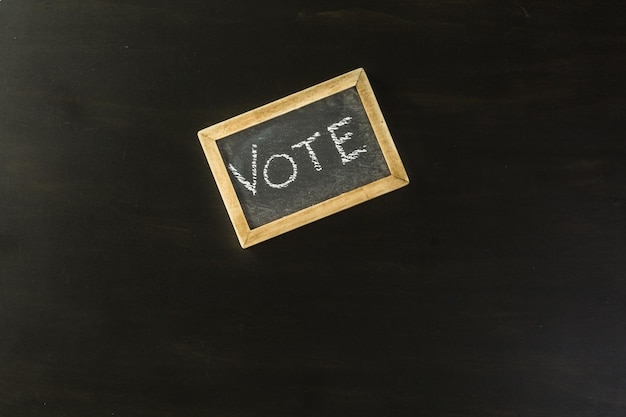 Vote sign on chalk board next to the American Flag.