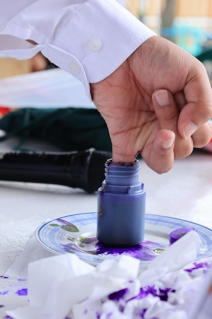 Voter Dipping His Pinkie into Ink Bottle to Proof Already Cast the Ballot