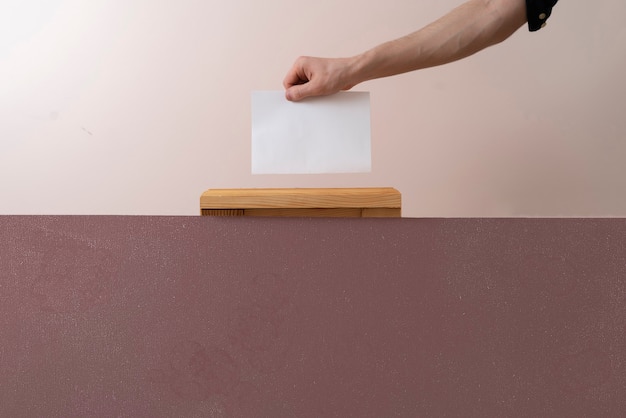 A voter hand put paper in the urn, democracy election