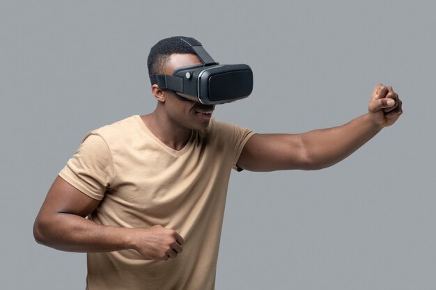 Vr. african american young man in vr glasses looking involved