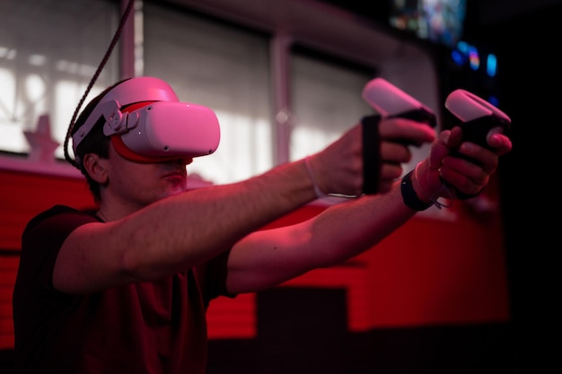 Фото vr игра и виртуальная реальность человек геймер весело играть на футуристической симуляции видео стрельбы