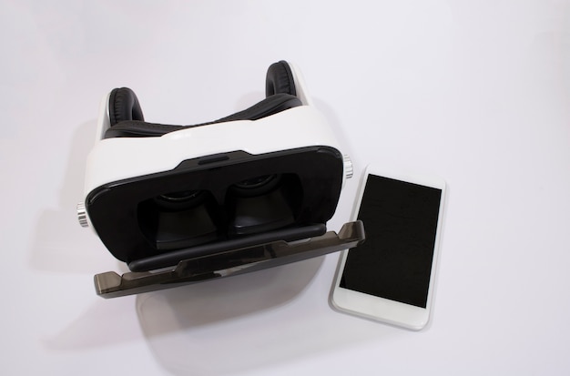 Foto occhiali vr o casco per realtà virtuale auricolare con telefono cellulare isolato su bianco