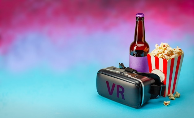 집 VR 안경 헬멧과 팝콘, 맥주 한 병의 화려한 배경 복사 공간에서 VR 영화
