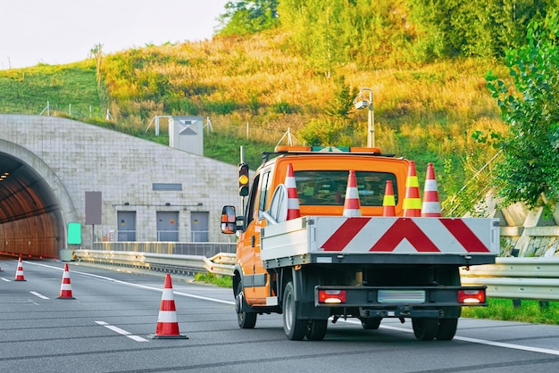 Vrachtwagen met aanhanger met verkeersveiligheidskegels op de asfaltweg van Slovenië.