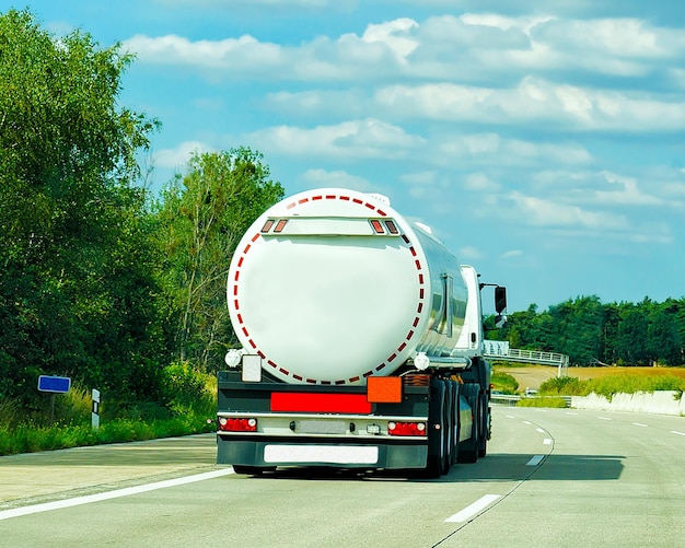 Vrachtwagen met vloeistof- of olieopslag in de weg of snelweg van Duitsland. Vrachtwagen met tanktank bij logistiek werk. Oplegger tank. Lading auto rijden. Vracht levering. Transport export industrie