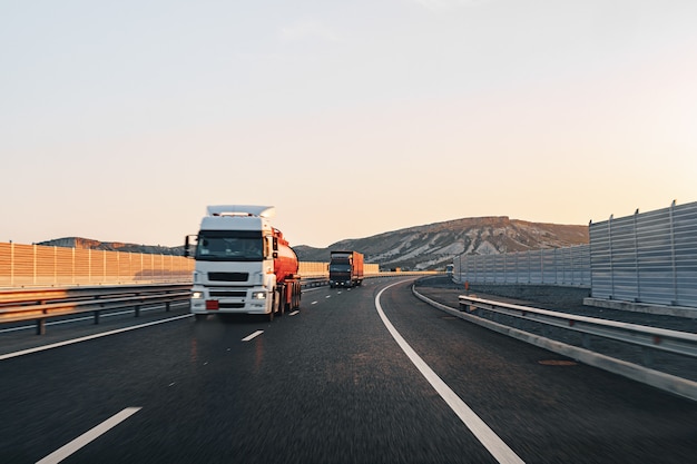 Vrachtwagen rijden op snelweg weg bij zonsopgang