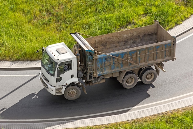 Vrachtwagendump van het lichaam voor lading op de snelweg rijdt langs het asfalt bovenaanzicht
